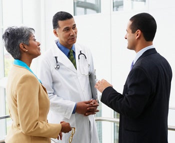 Doctor talking with business man and woman