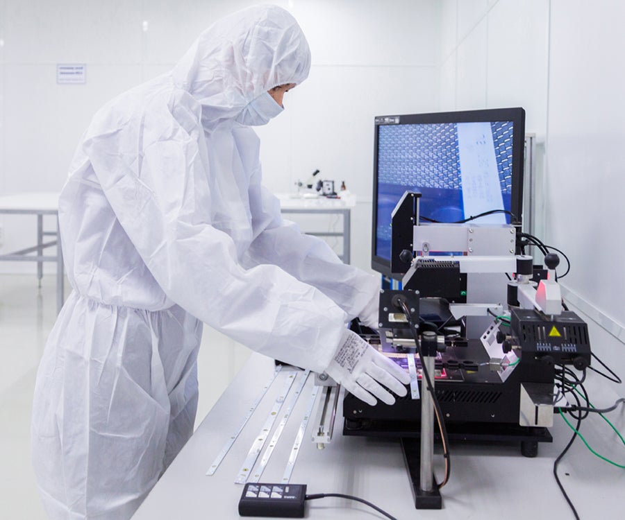 Cleanroom technician working on semiconductor & FPD equipment.