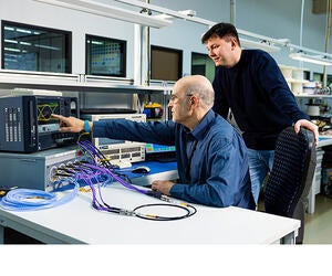 Two Associates working with a machine to test products.